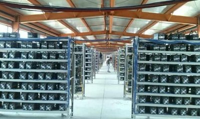 A picture of a mining farm facility with rows of mining machines