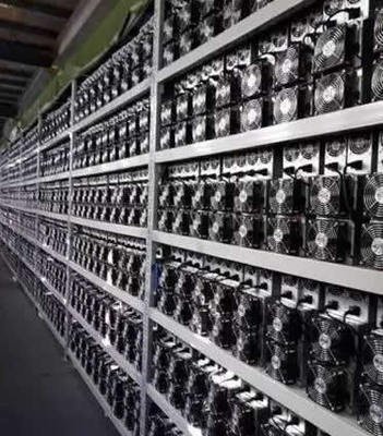 A view of a mining farm showing rows of mining rigs and cooling systems.